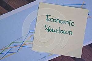 Economic Slowdown write on sticky notes isolated on Wooden Table photo