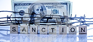 Economic warfare, sanctions and embargo busting concept. US Dollar money wrapped in barbed wire