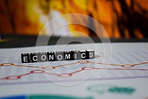 Economics on wooden blocks. Investment Income Profit Revenue Savings Concept
