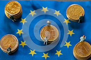 economy in in European countries.Figures of men in suits on euro coins on european union flags. Economic and political
