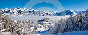 The Ecrins National Park mountains in the distance with Laye winter ski resort in Champsaur covered in fresh snow. Alps, France