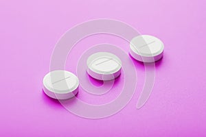 Ecstasy pills in a row on a pink background, isolate