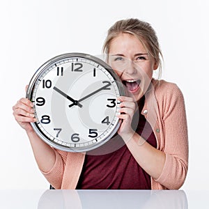 Ecstatic beautiful young blond woman holding a clock