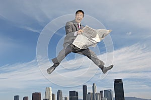 Ecstatic Businessman Holding A Newspaper