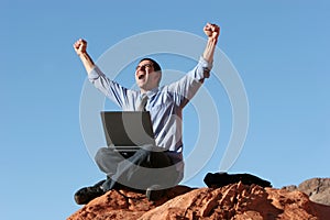 Ecstatic businessman working on laptop