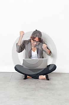 Ecstatic businesswoman raising her hands for corporate victory