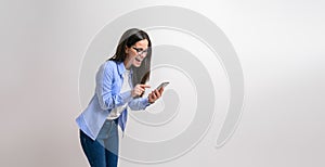 Ecstatic female professional laughing and scrolling on smart phone against isolated white background