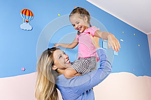 Ecstatic, happy mother and daughter playing