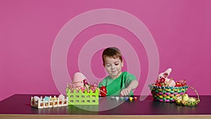 Ecstatic little kid using watercolor and paintbrushes to decorate eggs