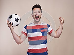 Ecstatic male fan with soccer ball cheering