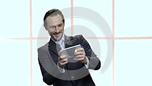 Ecstatic mature businessman playing mobile game.
