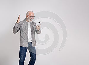 Ecstatic old male entrepreneur screaming after reading good news over smartphone on white background