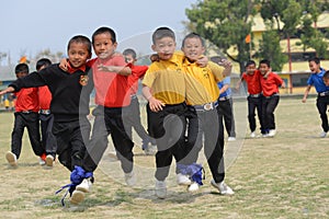 Ecstatic school students competing in three legged race