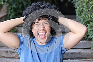 Ecstatic South American man with afro hairstyle screaming