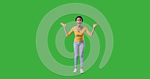 Ecstatic woman celebrating success over green background