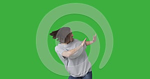 Ecstatic woman dancing over green background