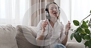 Ecstatic woman singing while listening to music in headphones