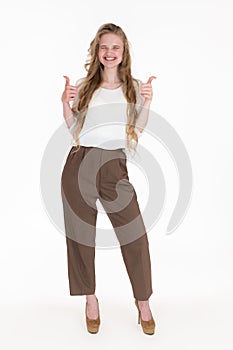 Ecstatic woman with toothy smile and eyes closed showing thumbs up with both hands. Full length