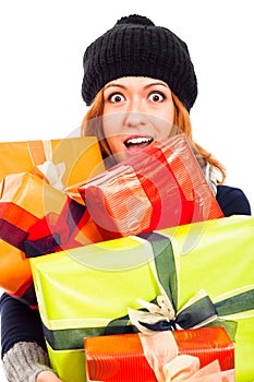 Ecstatic woman in winter hat with many gifts