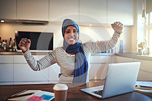 Ecstatic young Arabic woman celebrating her business success at