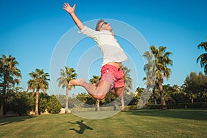 Ecstatic young casual man jumping of joy outside