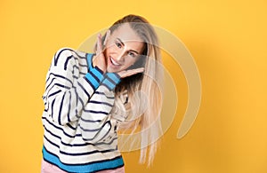 Ecstatic young women, isolated on yellow background. Gorgeous girl wears sweater