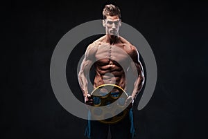 Ectomorph shirtless athletic male holds barbell weight.