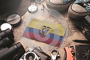 Ecuador Flag Between Traveler`s Accessories on Old Vintage Map. Tourist Destination Concept