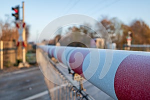 ed and white level crossing railway barrier covered with frost which block the road on countryside.