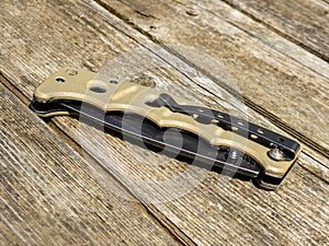 Edc pocket knife on wooden background.