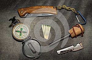 EDC. Wearable survival kit. Folding knife, compass and hunting matches with flint. Tools for overnight in the forest. Tools for