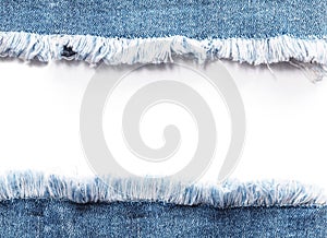 Edge frame of blue denim jeans ripped over white background.