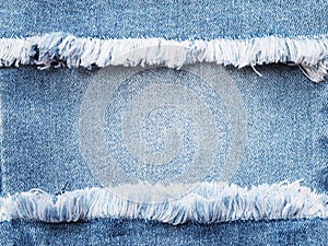 Edge frame of blue denim ripped over jeans texture background.