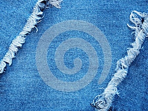 Edge frame of blue denim ripped over jeans texture background