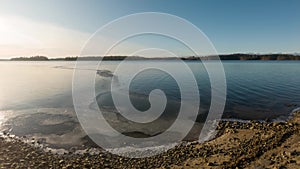 Edge of ice cover at freezing lake. Time lapse shot.