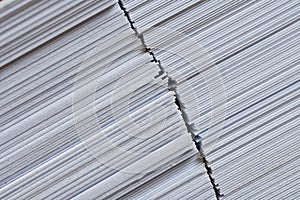 The edge of many sheets of white cardboard or heavy paper. Diagonal crack. Background or substrate