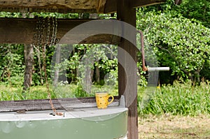 Edge of old well pulley with chain and mottled cup