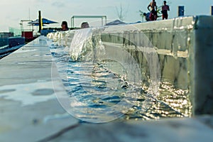 Edge of overflow swimming pool. Water cascade