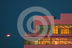 Edge of pink building with roof on the background of the blue sky in clear weather. Minimalism, abstract and conceptual photo