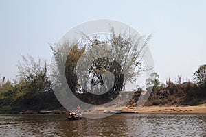 On the edge of the river in South Asia  fishermen ride on boats.