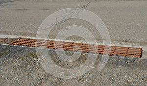 At the edge of the road is a concrete trough for collecting rainwater. for cars and cyclists to cross this drainage gutter with th
