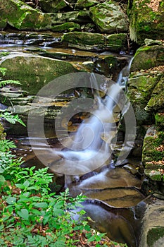 Edge of the waterfall on a craggy stones with moss