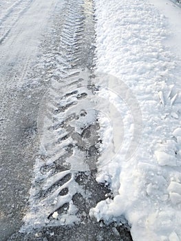 The edge of the winter road. Tyre tracks imprinted into snow