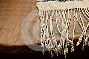 Edge of the wood table with a homespun towel