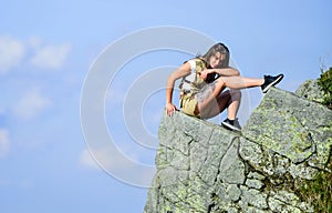 On edge of world. Woman sit on edge of cliff in high mountains blue sky background. Hiking peaceful moment. Enjoy the