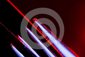 Edges of two illuminated  serrated knives and prongs of a fork macro shot suitable as a background