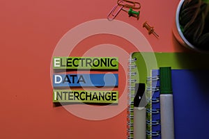 EDI. Electronic Data Interchange acronym on sticky notes. Office desk background