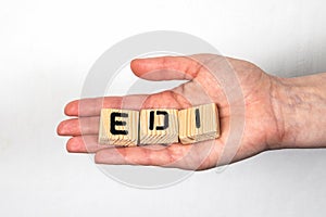 EDI Electronic Data Interchange. Alphabet wooden blocks in a woman& x27;s hand