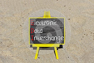 EDI electronic data interchange symbol. Concept words EDI electronic data interchange on blackboard. Beautiful sand background.