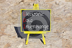 EDI electronic data interchange symbol. Concept words EDI electronic data interchange on blackboard. Beautiful stone background.